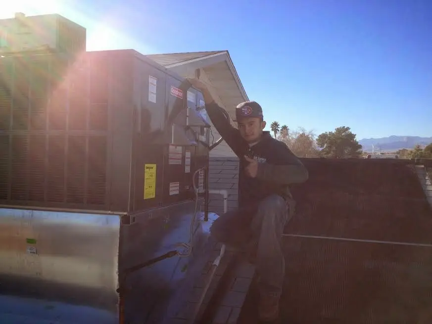 HVAC technician performing Boiler Repair on a rooftop unit in Merriam